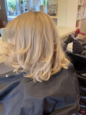 Blonder Stufenschnitt mit Volumen, frisch geföhnt